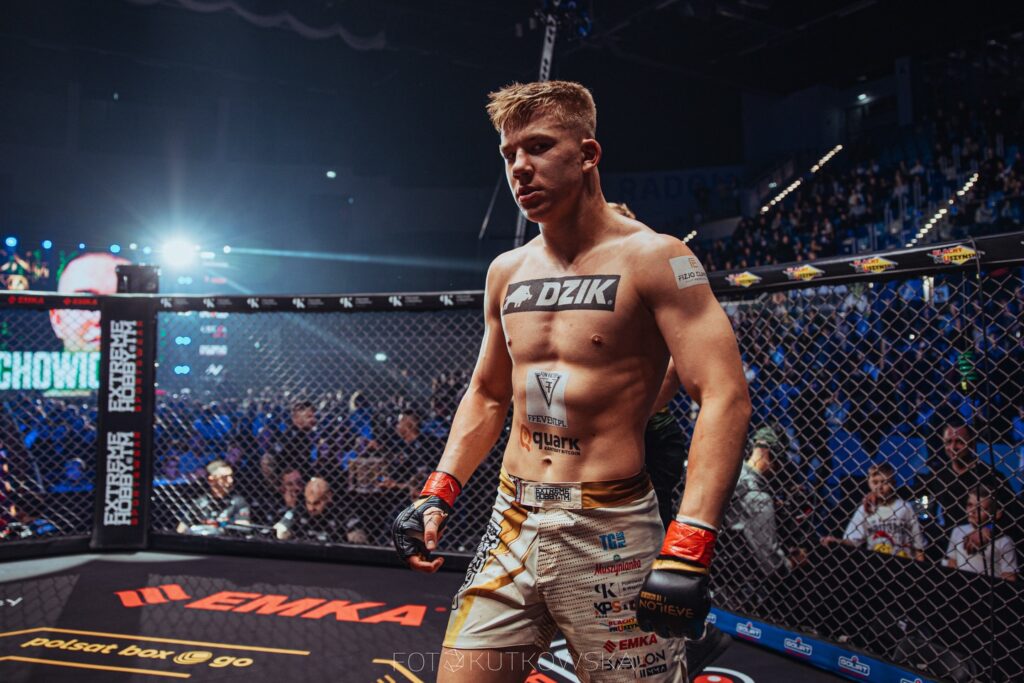 Stanisław Telejko w klatce podczas walki MMA, sponsorowany przez Bitcoin Quark